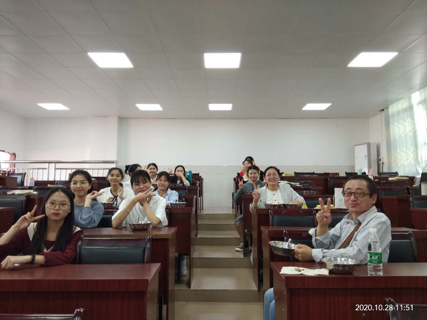 图为老师对学生进行评课后合影