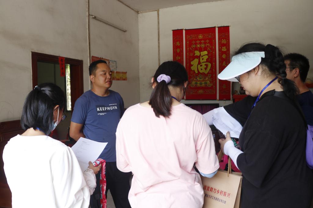 图为实践团成员在居民家做普通话现状的问卷调查